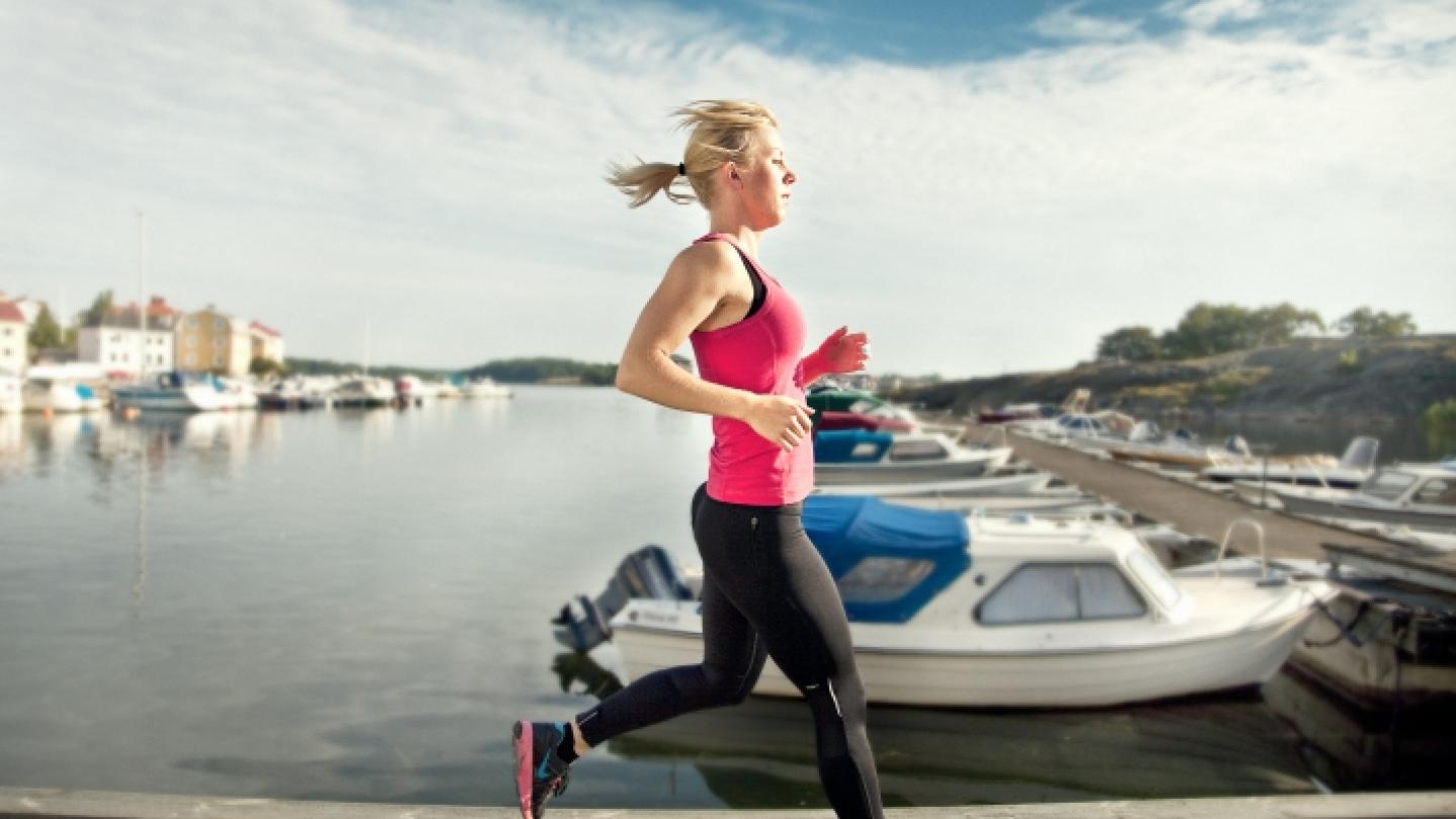 Kvinna som joggar längs Borgmästarefjärden