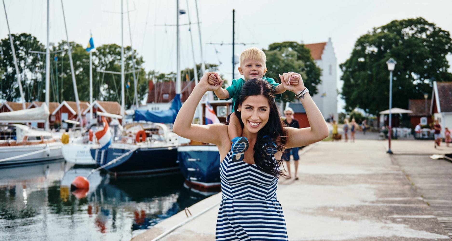 Kvinna med barn på axlarna i Kristianopels hamn