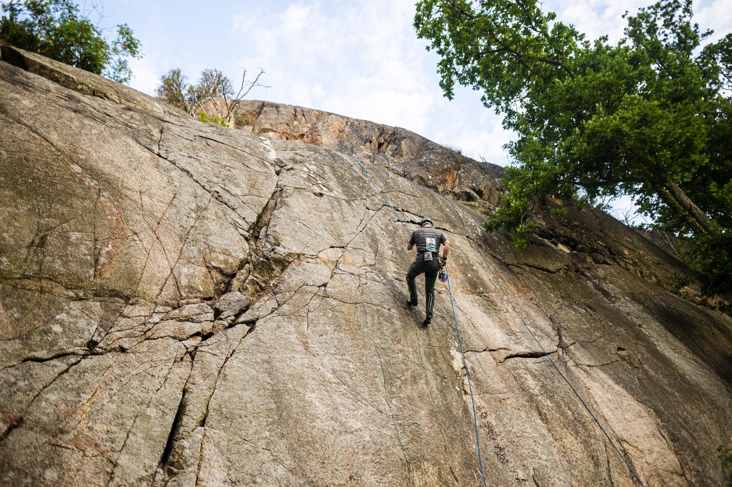 Klättrare börjar klättra nerför bergvägg