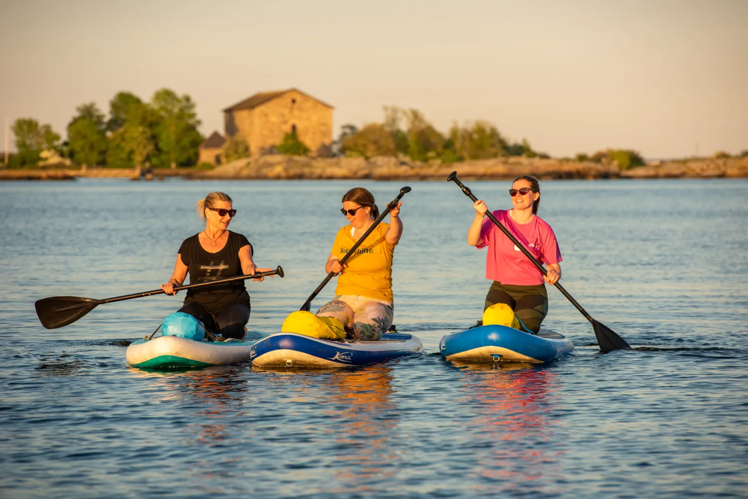 Tre paddlande kvinnor på SUP