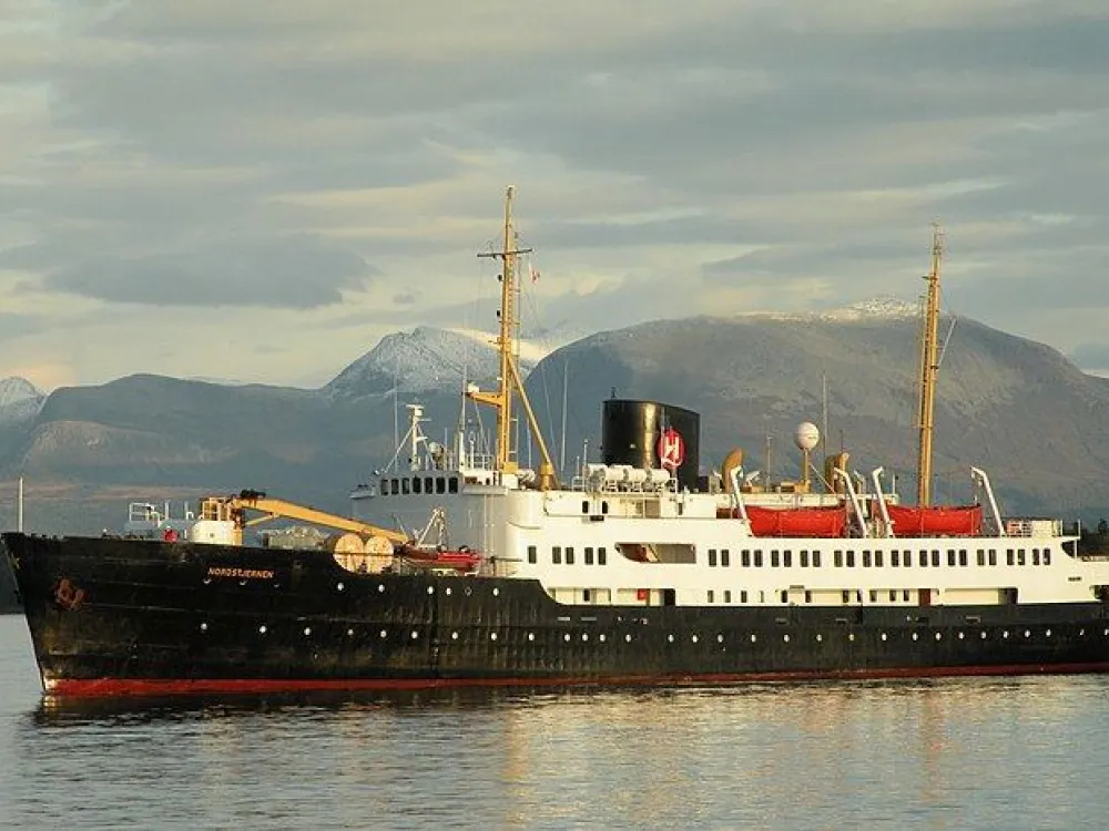 MS Nordstjernen på havet med berg bakom