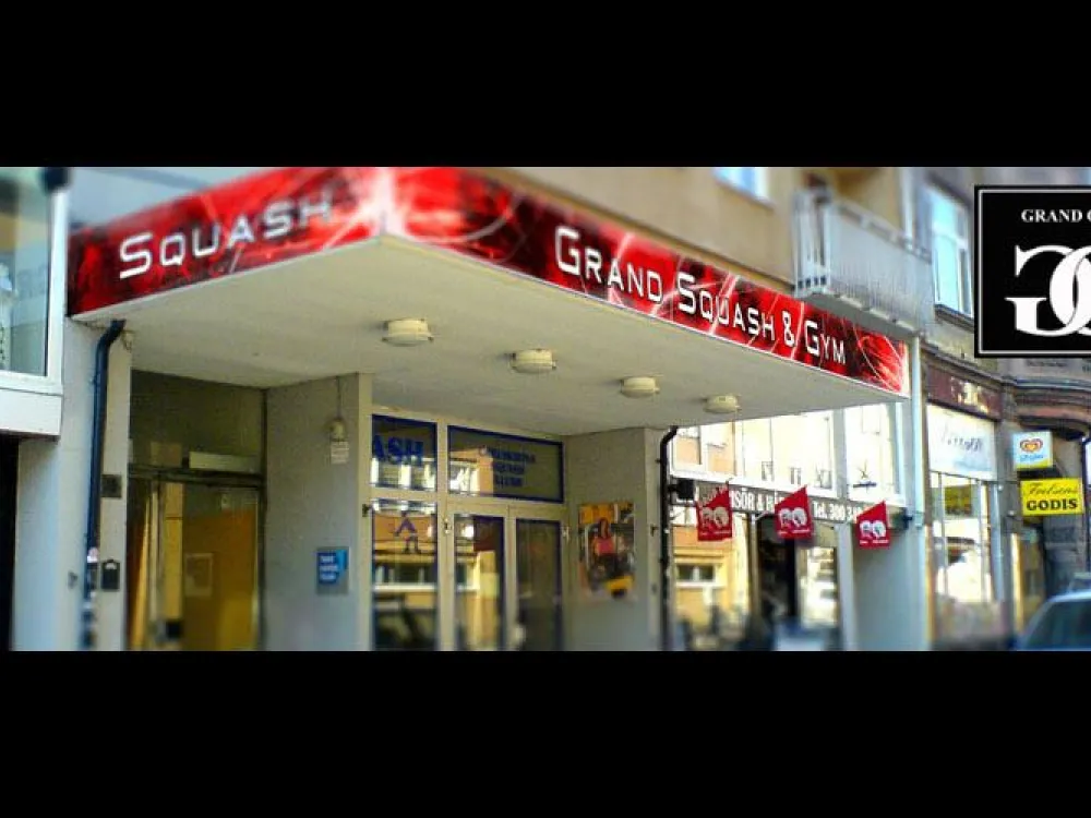 Röd skylt med texten Grand Squash & Gym vid entrén