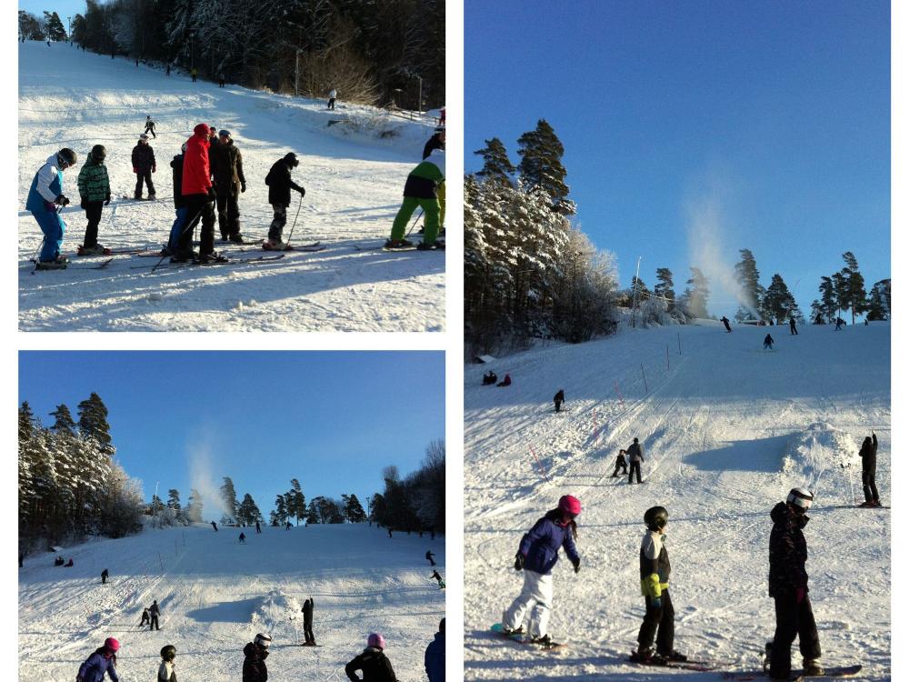 Flera personer som åker skidor och snowboard i backen