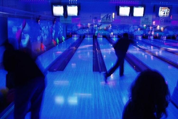 En Bowling hall med personer som spelar bowling i blått ljus