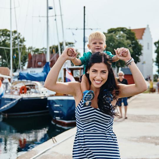 Kvinna med barn på axlarna i Kristianopels hamn