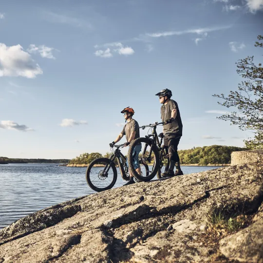 Två cyklister blickar ut över skärgården